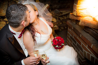 newly weds toasting in front of fireplace